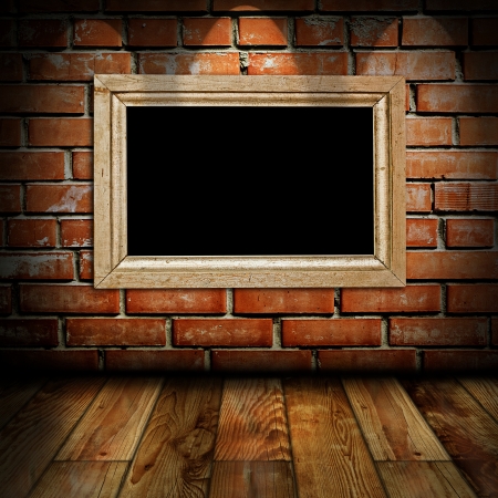 empty vintage frame in a room against a brick wallの写真素材