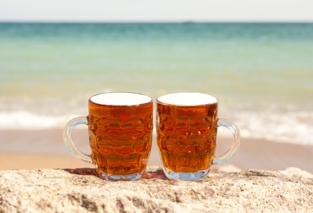 Two glasses of cold beer on the sea beachの写真素材