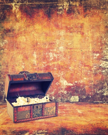 treasure chest with jewelry inside against grunge backgroundの写真素材