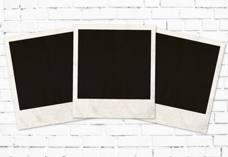 three photo frames against white brick wallの写真素材