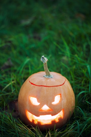 halloween jack-o-lantern on green grassの写真素材
