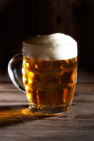Mug of beer on wooden の写真素材