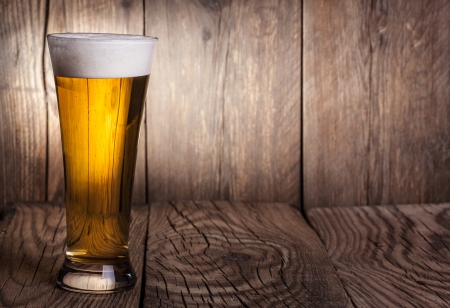 Mug of beer on wooden background の写真素材
