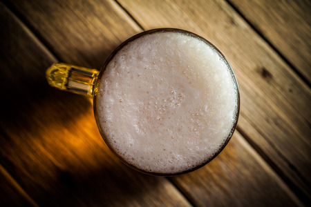 Mug of beer on wooden backgroundの写真素材