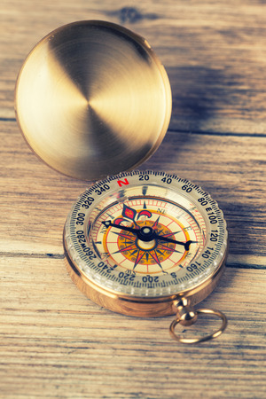 Antique brass compass over wooden background の写真素材