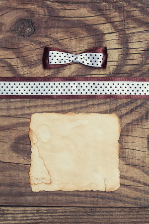 vintage background with wood, old paper and brown and white polka dot ribbon with bowの写真素材
