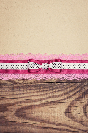vintage background with wood, old paper and pink and white polka dot ribbon with bowの写真素材