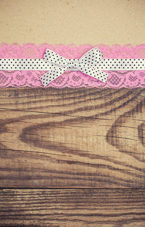 vintage background with wood, old paper and pink and white polka dot ribbon with bowの写真素材