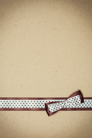 brown and white polka dot ribbon with bow on old paperの写真素材
