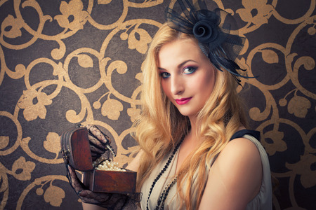 beautiful retro woman opeing a chest with jewelry