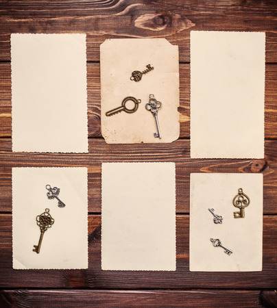 old paper sheets with vintage keys on wooden backgroundの写真素材