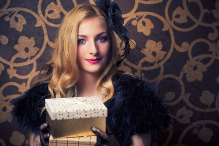 beautiful retro woman holding a golden gift box