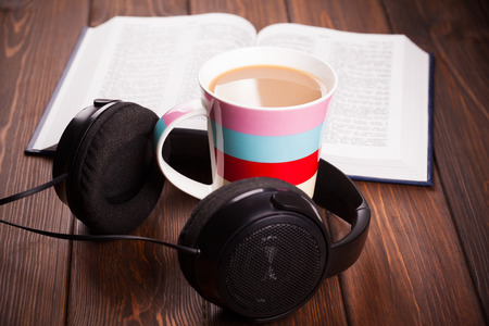 cup of coffee with headphones on wooden background の写真素材