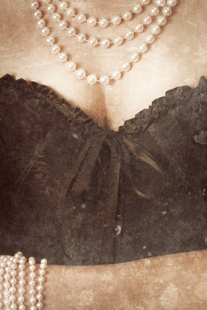 woman wearing black corset and pearls against retro backgroundの写真素材