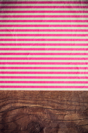 pink striped paper laying on wooden tableの写真素材