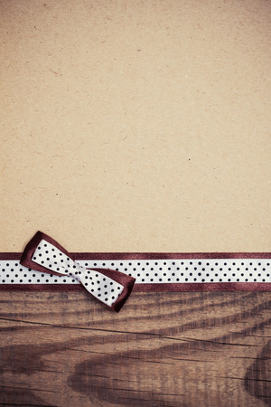 vintage background with wood, old paper and brown and white polka dot ribbon with bowの写真素材