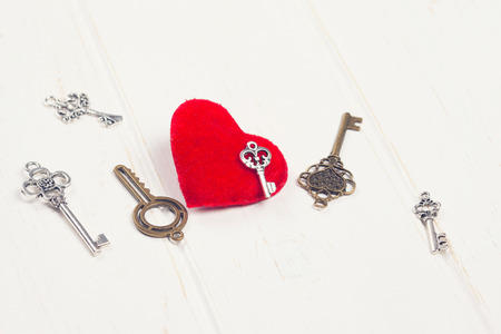 vintage key and red heart on wooden background の写真素材