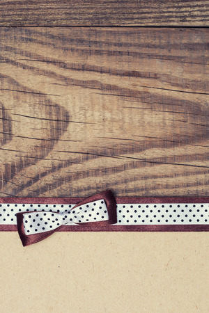 vintage background with wood, old paper and brown and white polka dot ribbon with bowの写真素材