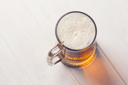 Mug of beer on wooden background の写真素材