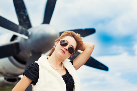 beautiful woman wearing sunglasses against planeの写真素材