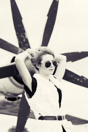 beautiful woman wearing sunglasses against planeの写真素材