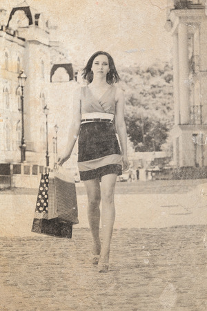 beautiful young woman holding shopping bags on a city streetの写真素材