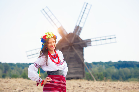 beautiful young woman wearing national ukrainian clothes posing outdoorsの写真素材
