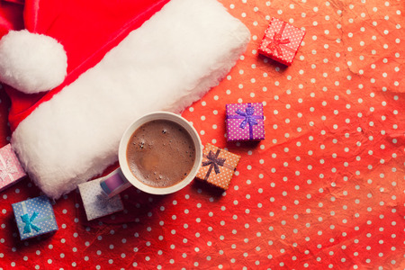 Christmas santa hat with a cup of coffeeの写真素材