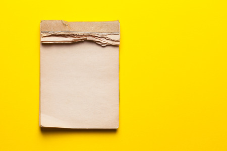 old notebook on yellow backgroundの写真素材