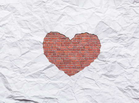 White torn paper in heart shape symbol over brick wall backgroundの写真素材