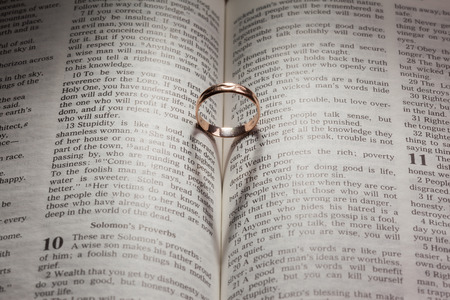 Wedding Ring and heart shaped shadow over a book