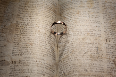 Wedding Ring and heart shaped shadow over a bookの写真素材