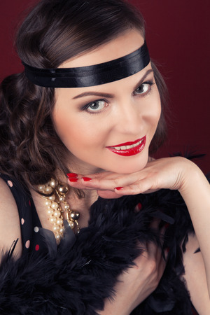 beautiful retro woman posing against wine red background
