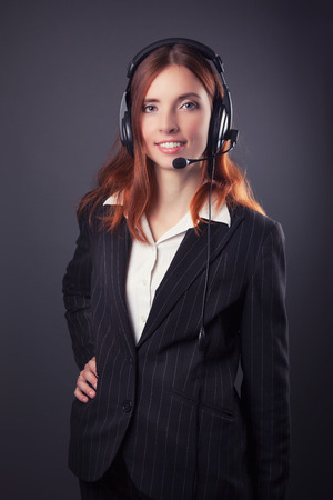 beautiful business woman with headphones against dark grey backgroundの写真素材