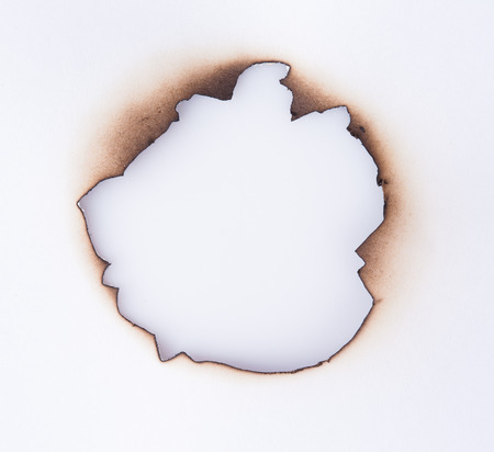 Burnt hole on a white paperの写真素材