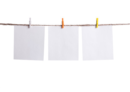 Blank instant photo hanging on the clothesline. Isolated on white backgroundの写真素材