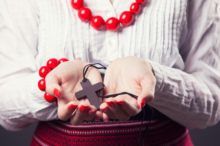 beautiful young woman wearing national ukrainian clothes and praying with rosary in handsの写真素材