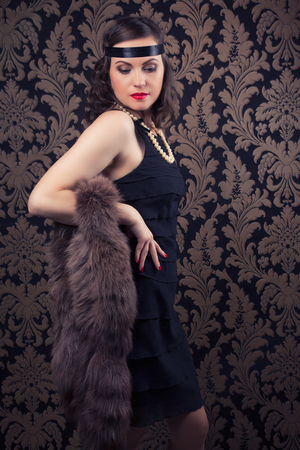 beautiful retro woman posing against vintage wallpapers