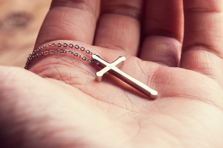 Silver cross in a hand  close up imageの写真素材