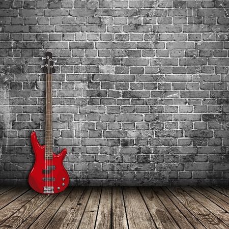 red electric guitar in the room with brick wall backgroundの写真素材