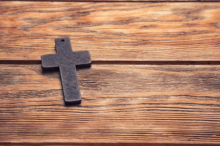 Old cross on a brown wood background