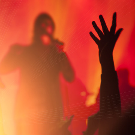 Silhouettes of people and musicians in big concert stage. Bright beautiful rays of lightの写真素材