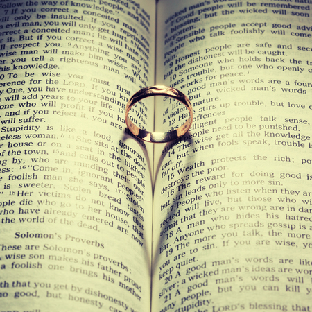Wedding Ring and heart shaped shadow over a bookの写真素材