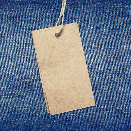 blue jeans background with brown paper label