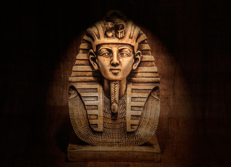 Stone pharaoh tutankhamen mask on papyrus backgroundの写真素材