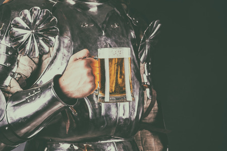 knight wearing armor and holding mug of beer