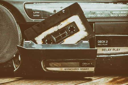 old cassette tape and player on the old brown wooden background