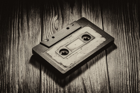 Old audio cassette on a brown wooden backgroundの写真素材