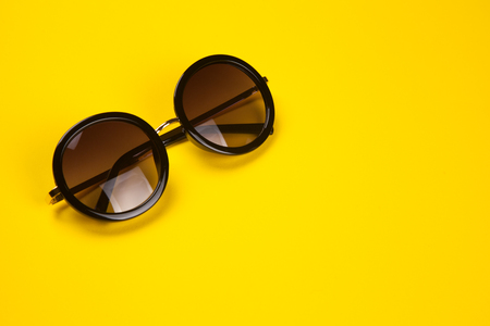 Stylish sunglasses on a yellow paper backgroundの写真素材