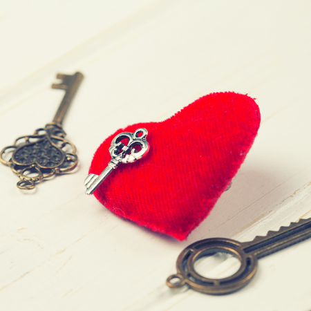 vintage key and red heart on wooden backgroundの写真素材